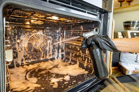 Person cleaning an oven